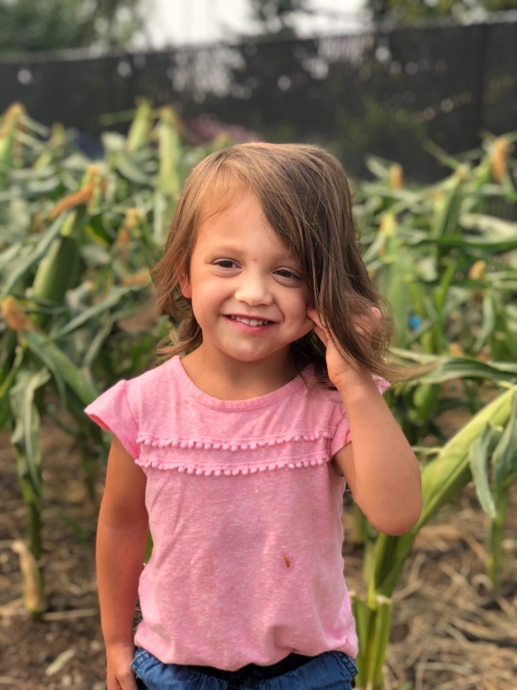 Little VIP student smiling in front of the corn she helped grow