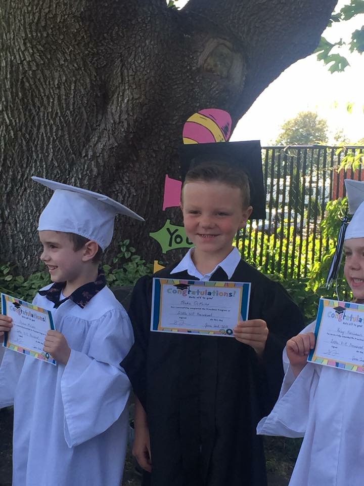 Three Little VIP graduates holding their certificates under the big tree